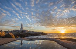 L'affascinante baia di Peggy's Cove con il faro al tramonto nei pressi di Halifax, Nuova Scozia, Canada. E' solo una delle suggestive località che costellano il litorale della ...