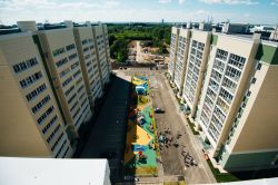 Bambini e genitori si divertono nell'area attrezzata fra moderni complessi residenziali a Samara, Russia. Una suggestiva veduta dal tetto di un edificio - © knyazevfoto / Shutterstock.com ...