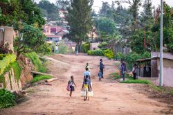 Bambini ruandesi a Kigali portano acqua dalla pompa pubblica in una strada residenziale - © Stephanie Braconnier / Shutterstock.com