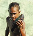 Bambino con pesce a Ouva, isola dell'arcipelago della Nuova Caledonia, Oceania.
