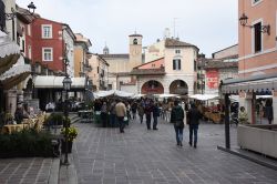 Bancarelle in una piazzetta di Desenzano del Garda, provincia di Brescia - © Claudiovidri / Shutterstock.com