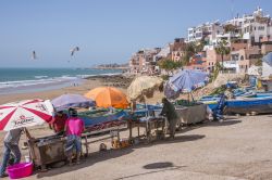 Bancarelle per la vendita del pesce sulla spiaggia di Taghazout, Marocco. La pesca, così come la produzione di olio d'argan e il turismo, rappresenta una delle principali fonti economiche ...