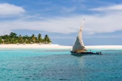 La barca a vela di un pescatore passa davanti alla spiaggia di Nosy Iranja (Madagascar). L'isola si trova ad un'ora e mezza di navigazione dalla più famosa Nosy Be Pierre ...