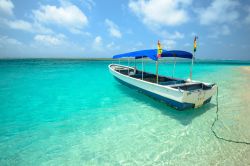 Una barca da turismo ormeggiata sulla spiaggia delle isole di San Blas, Panama. L'arcipelago è ubicato al largo della costa nord dell'istmo di Panama.
