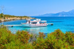 Barca di turisti ormeggiata a Lotu nei pressi di Saint Florent, Corsica, Francia. Una passeggiata lungomare permette di ammirare da vicino i colori del mare e della terrra di questo angolo di ...