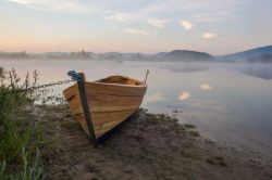 Barca sulla riva del Lago di Cerknica, Slovenia - Le luci del tramonto si riflettono sullo specchio d'acqua più famoso della Slovenia. Sulle sue sponde vengono ormeggiate imbarcazioni ...