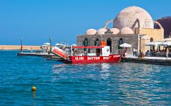 Una barca turistica rossa davanti alla moschea Hasan Pasha in attesa della partenza, Chania, Creta - © eFesenko / Shutterstock.com 