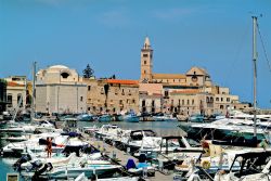 Barche al molo di Trani con edifici e la cattedrale di San Nicola Pellegrino sullo sfondo, Puglia. La città è conosciuta come la "perla dell'Adriatico" - © fritz16 ...