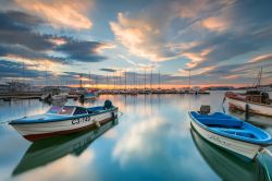 Barche da pesca al tramonto nel porto di Sozopol, Bulgaria. La parte vecchia della città sorge sulla penisola Stolez, collegata da un istmo artificiale con l'isola di San Cirillo ...