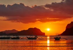 Barche nella baia di El Nido al tramonto, isola di Palawan, Filippine.

