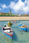 Barche ormeggiate vicino alla spiaggia di Caorle, Veneto. Sullo sfondo, il bel borgo alle porte di Venezia situato alla foce dei fiumi Livenza e Lemene.



