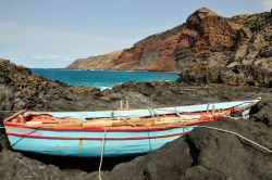 Barchetta dei pescatori sulle rocce nere del litorale dell'isola di Fogo (Capo Verde).
