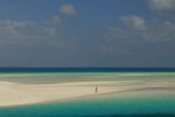 Bassa marea a Ouva, Nuova Caledonia. Una turista cammina sulla lingua di sabbia. 
