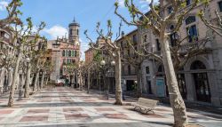 Un bel viale alberato nel centro cittadino di Olot, Spagna, con eleganti edifici affacciati - © joan_bautista / Shutterstock.com
