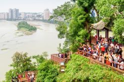 Una bella veduta della città di Leshan e della confluenza del Min River (Min Jiang) e del Dadu River, Cina. In primo piano, turisti sul belvedere della Statua Gigante del Buddha - © ...