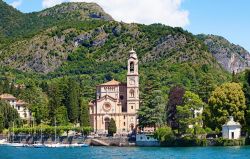 Una foto scattata dall'acqua verso la riva del lago, con il particolare della chiesa e delle montagne che circondano il lago di Como - foto © Fedor Selivanov / Shutterstock.com