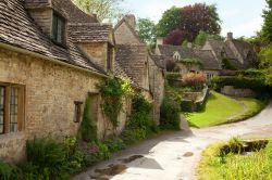 Case in pietra tra le colline dei Cotswolds a Bibury, Inghilterra - Un tratto di strada che si inerpica nel villaggio di Bibury e su cui si affacciano le tradizionali case rurali in pietra e ...