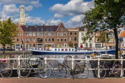 Biciclette parcheggiate lungo la ringhiera di un ponte a Haarlem, Olanda. Sullo sfondo, un'imbarcazione blu sul canale - © Marc Venema / Shutterstock.com