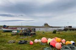 Boe da pesca e contenitori per aragoste a The Ouse Bay, Lindisfarne, Inghilterra.

