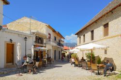 Caffè all'aperto in una stradina di Omodos, Cipro. Un uomo riposa al sole su una sedia - © Nikta_Nikta / Shutterstock.com