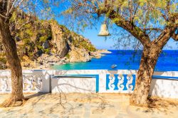 Una campana appesa su un albero nella spiaggia di Kyra Pynagia, isola Karpathos (Dodecaneso). Siamo in una piccola insenatura con spiaggia fra le rocce.

