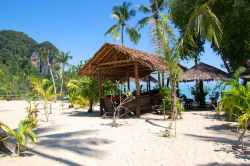 Capanne in paglia con tavolini e barche al riparo, isole di Koh Yao, Thailandia (Asia).
