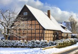 Edificio in mattoni dal tetto spiovente coperto di neve nelle campagne di Luneburg