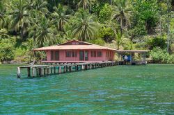 Una tipica casa caraibica con attracco per le barche sull'acqua e la foresta come sfondo, Bocas del Toro, Panama.

