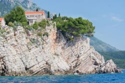 Case sulla roccia nell'isola di Sveti Stefan, Montenegro. In origine separata dalla terraferma, è ora collegata da uno stretto istmo artificiale.

