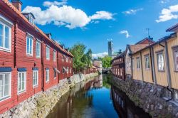 Casette colorate in legno a un piano o due affacciate su un canale a Vasteras, Svezia.



