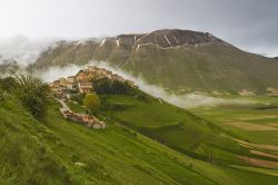 Castelluccio di Norcia fotografata dall'alto, prima del terremoto del 2016. A fare da cornice al centro abitato i Monti Sibillini con una leggera nebbia che ne sottolinea ancora di più ...