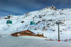 Chalet di legno e piste da sci con la funivia sulle Alpi francesi di Les Menuires.



