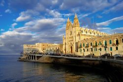 Chiesa di St Julian's, fotografata da una barca all'interno della Balluta bay a Malta, durante la calda luce del tramonto - © Mivr / Shutterstock.com