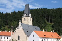 Chiesa e campanile a Rozmberk nad Vltavou, Repubblica Ceca. Cielo azzurro e vegetazione lussureggiante fanno da cornice a uno degli edifici religiosi più caratteristici di questa graziosa ...