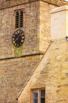 Chiesa in pietra di St Mary e orologio a Bibury, Inghilterra - Particolare della facciata in pietra color miele e dell'orologio che impreziosisce la chiesa di Santa Maria nel borgo di Bibury ...