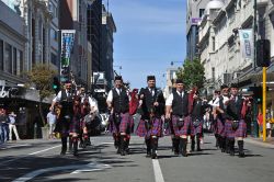 La Christchurch Pipe Band in marcia verso l'Octagon a Dunedin, Nuova Zelanda. L'Ottagono è il centro cittadino: si tratta di una piazza a otto lati divisa in due parti dalla strada ...