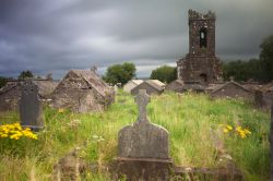 Cimitero irlandese nella penisola di Dingle, Irlanda. Nuvole e vegetazione creano un'atmosfera quasi surreale in questo piccolo cimitero irlandese dove vi sono anche le rovine di una vecchia ...