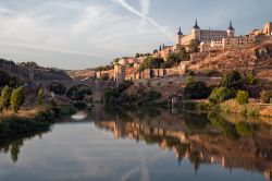 L'antico borgo di Toledo visto dal fiume Tago, con il Ponte di Alcàntara sullo sfondo e le tipiche sfumature rosate della luce pomeridiana - La Mancia Spagna 122279812 - © Gitanna ...