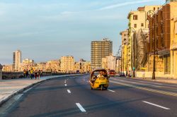 Un coco taxi sul Malecòn dell'Avana (Cuba) al tramonto. Questo mezzo è molto comodo per spostarsi in città da un quartiere all'altro - © Filipe Frazao / Shutterstock.com ...