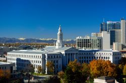 Colorado City Hall a Denver, Stati Uniti. Il bel Municipio cittadino fotografato con le Montagne Rocciose sullo sfondo e gli alberi in versione autunnale in primo piano.



