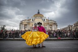 Uomo e donna travestiti da Catrina per celebrare la morte e i propri defunti durante la parata proposta in occasione del Giorno dei Morti. Sullo sfondo il Palazzo di Bellas Artes.
