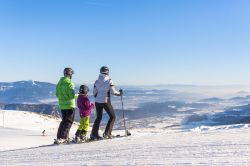 Una famiglia sulle piste da sci di Villach, Austria, in una giornata invernale soleggiata © FranzGerdl