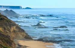 Costa atlantica e spiaggia di Carriagem con la bassa marea fotografate in una mattina d'estate a Aljezur, Portogallo.

