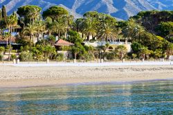 Un tratto della costa sabbiosa di Marbella, Spagna. Case e strutture ricettive si affacciano sul Mediterraneo circondate da palme e vegetazione lussureggiante - © Artur Bogacki / Shutterstock.com ...