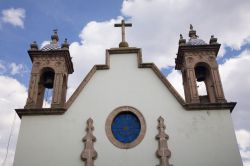 Dettaglio architettonico di una chiesa con due campanili a Morelia, Messico. La facciata realizzata con intonaco bianco è impreziosita dal rosone con vetri blu.





