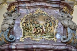 Dettaglio di una colonna di marmo rosso nella cattedrale di San Pietro a Osnabruck, Germania. La scena religiosa rappresentata è in rilievo e ricoperta da una doratura - © Alizada ...