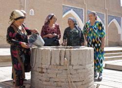 Donne uzbeke in costume tradizionale in un pozzo di Khiva - © alfotokunst / Shutterstock.com