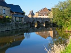 Ducey-les-Cheris, Francia: l'antico ponte in pietra riflesso nelle acque del fiume Selune.

