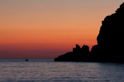 Due pescatori al tramonto su una barca al largo di Capo Vaticano, Ricadi, Calabria.
