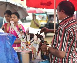 Due ragazze acquistano noccioline arrostite da un venditore ambulante a Trivandrum, India - © Ajayptp / Shutterstock.com 